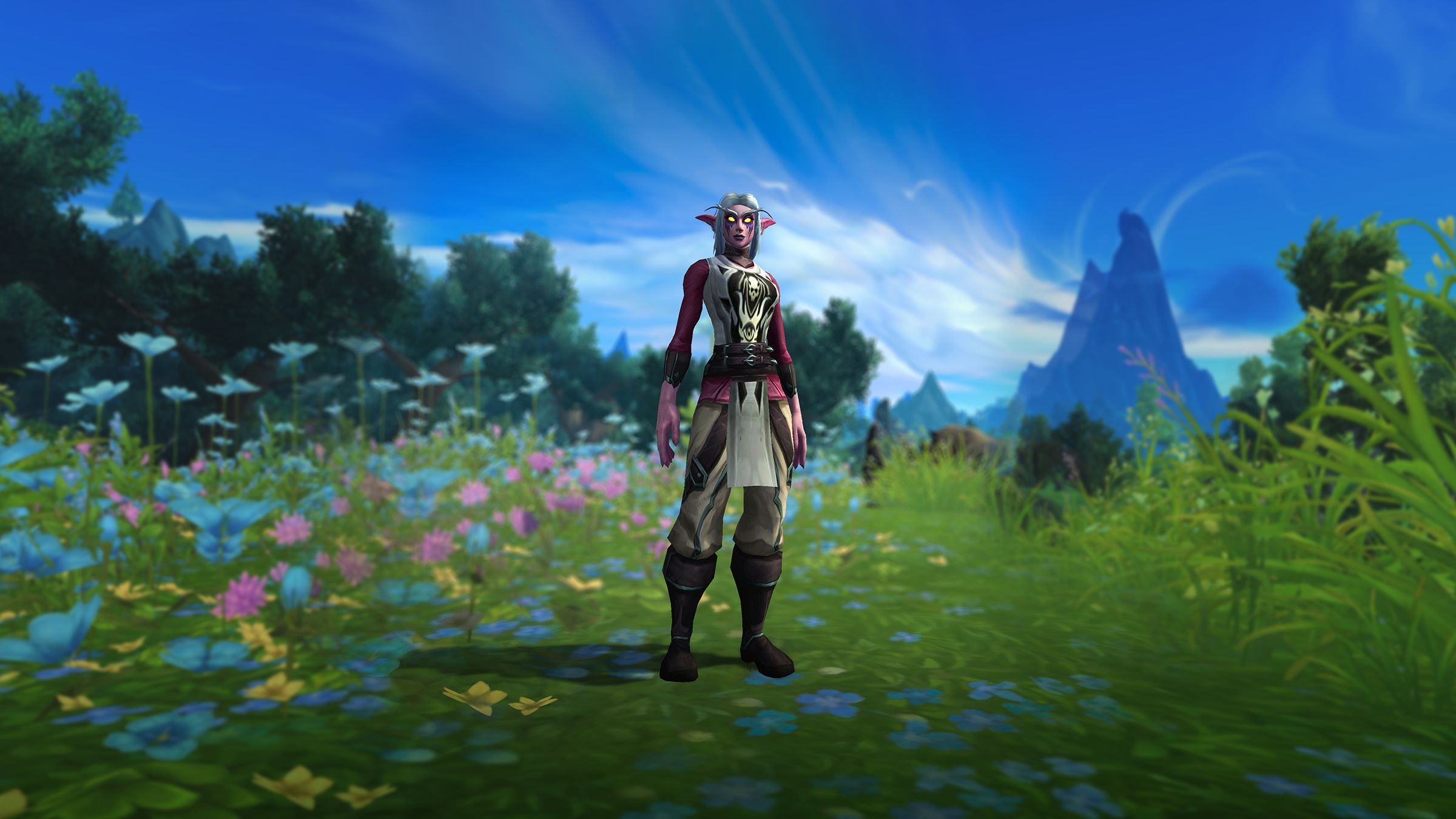A Night elf stands on a flowery meadow sporting the festive Tabard of Brilliance.