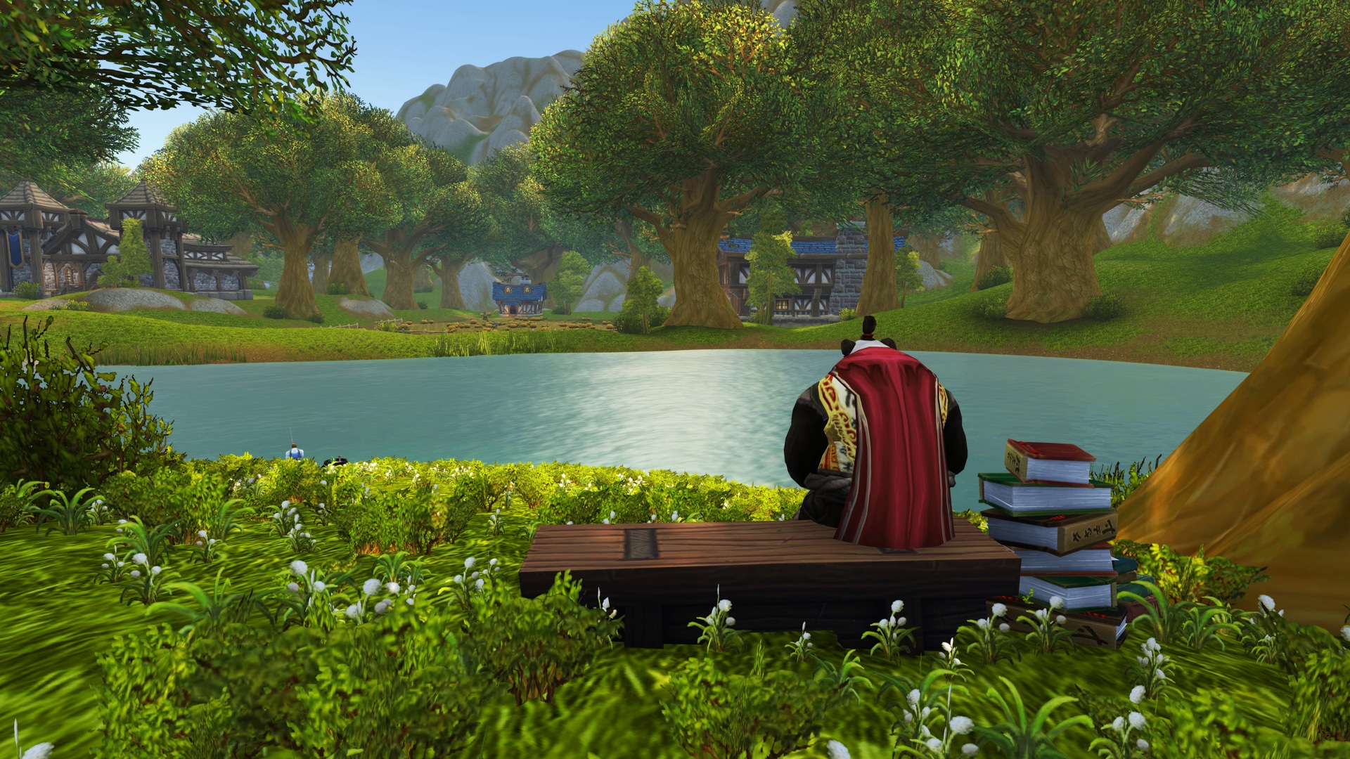 a pandaren sitting on a bench facing away toward a pond with a stack of books next to him