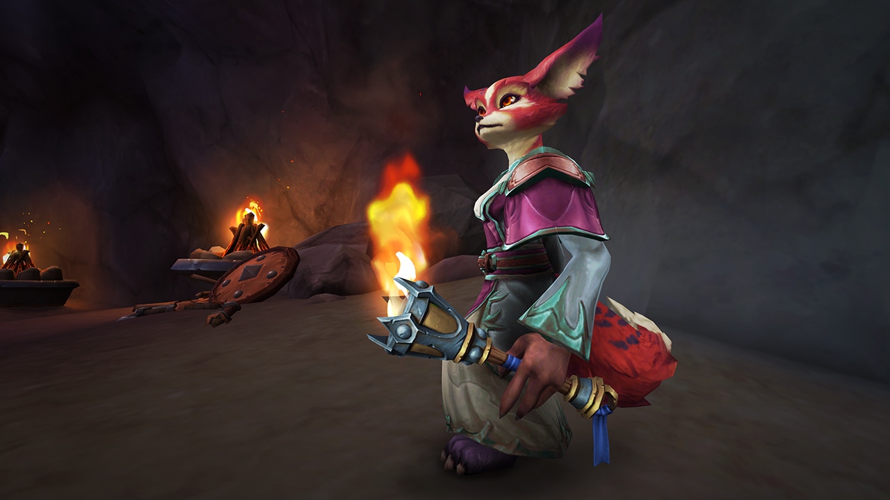 Vulpera holding the torch while standing in a cave