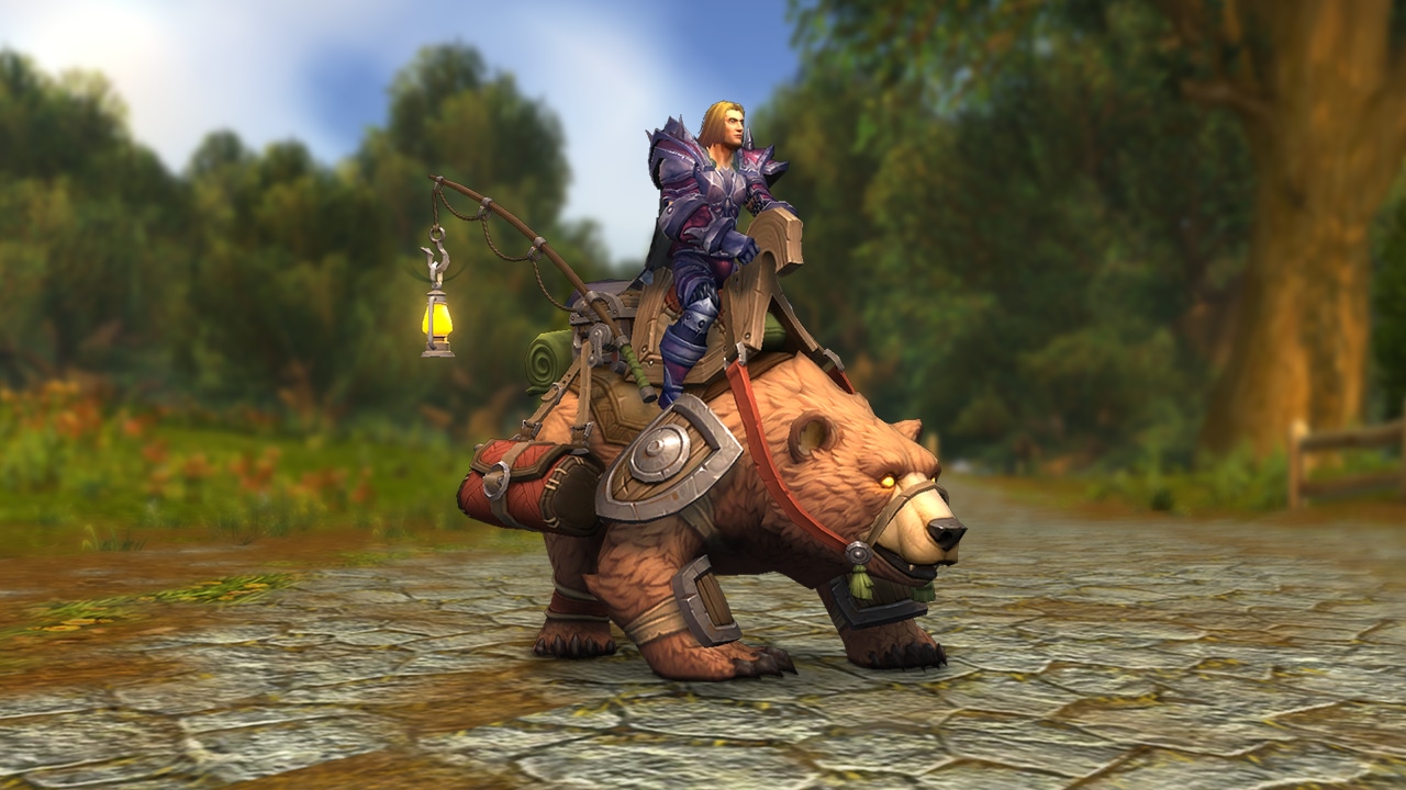 Human Male riding on the back of a brown lightly armored grizzly bear with saddle bags. 